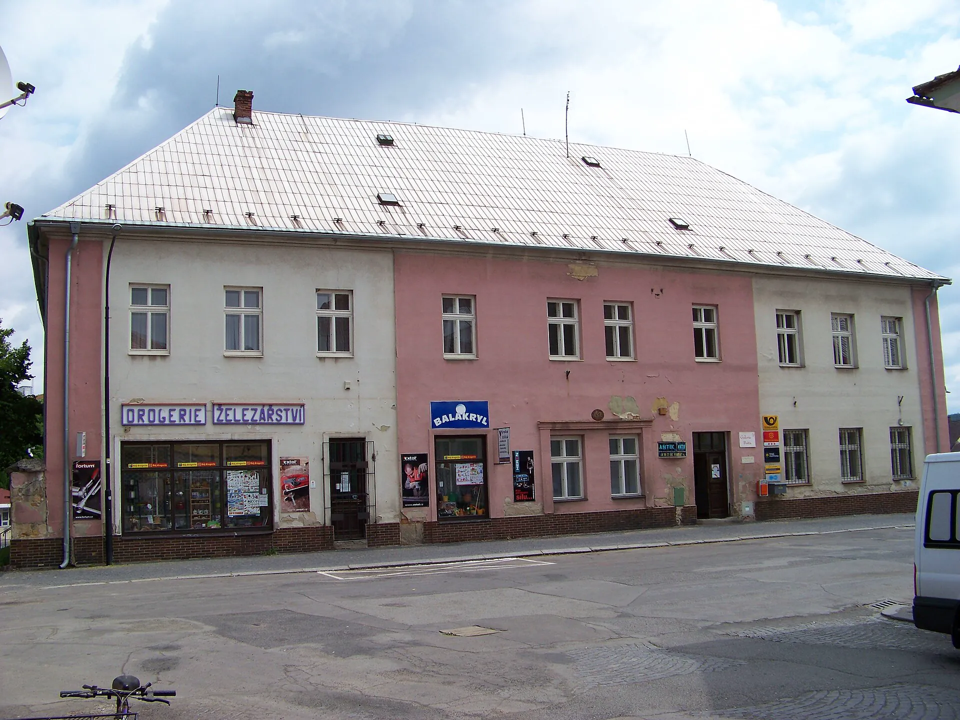 Nárožní budova bývalé pošty v Dubé s modrým poutačem galerie