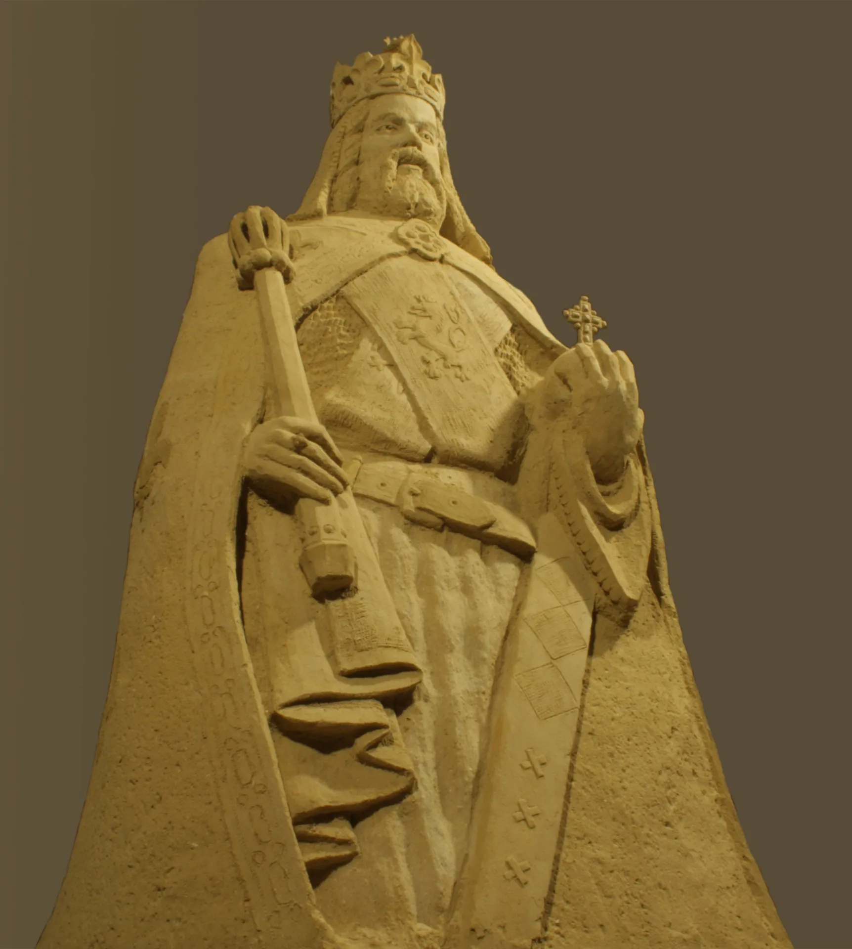 Detail pískové sochy císaře Karla IV. s korunou a žezlem