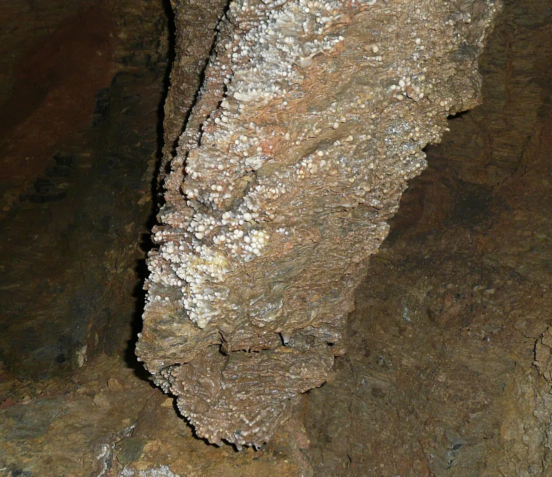 Detail hrubé sintrové výzdoby pokrývající stěnu jeskyně
