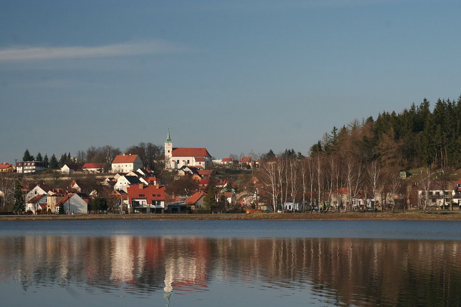 Kostel a domky Jedovnic odražené ve vodě rybníku