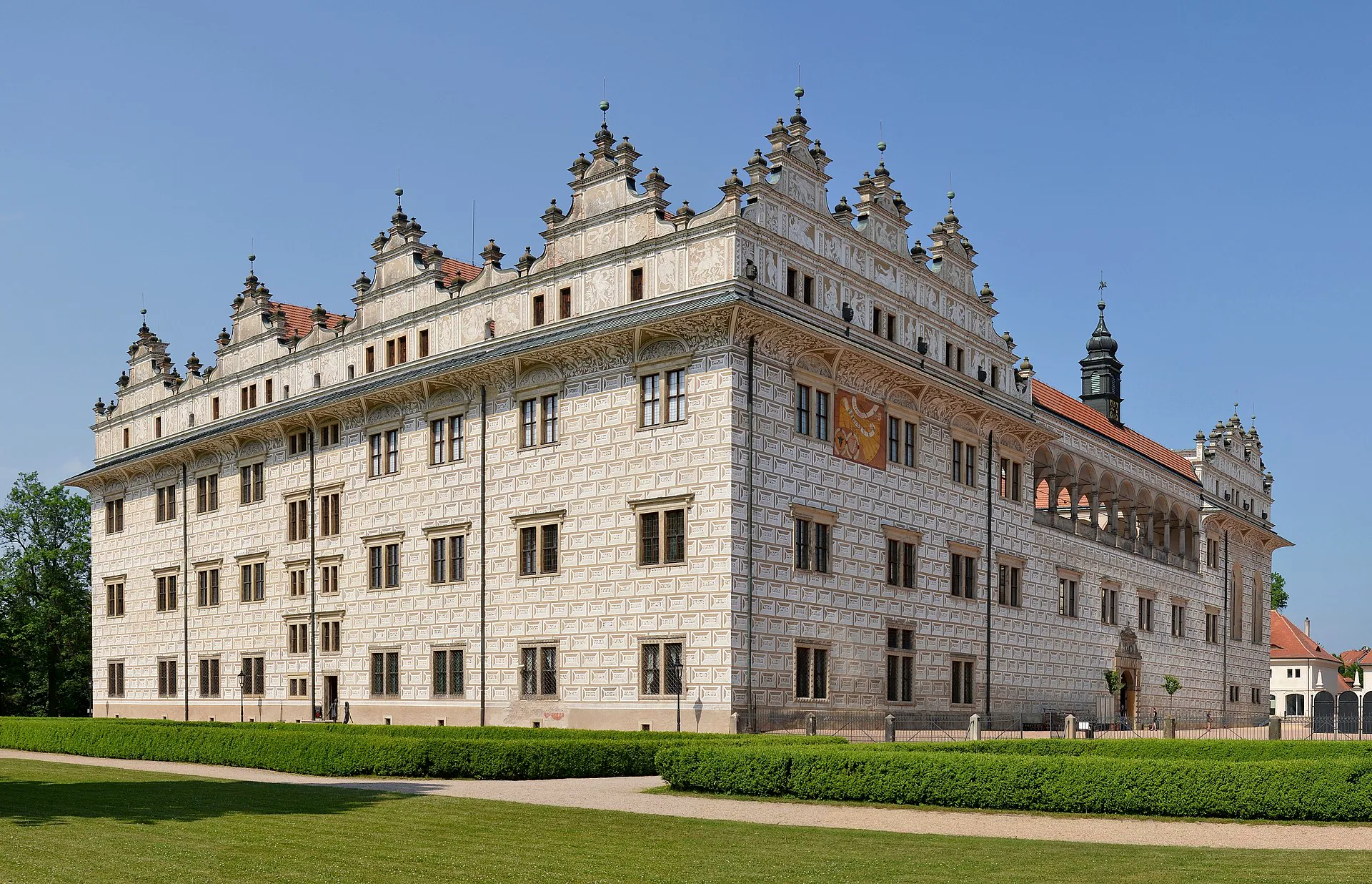 Průčelí zámku se sgrafitovou fasádou a řadou volutových štítů