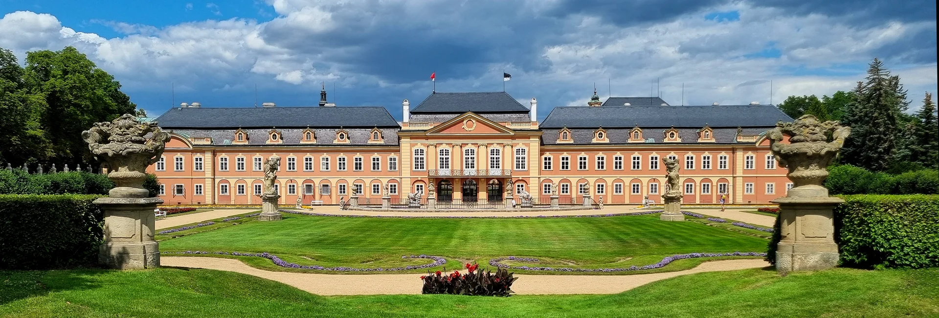 Široký pohled na rokokový zámek Dobříš z Francouzského parku s travnatým parterem
