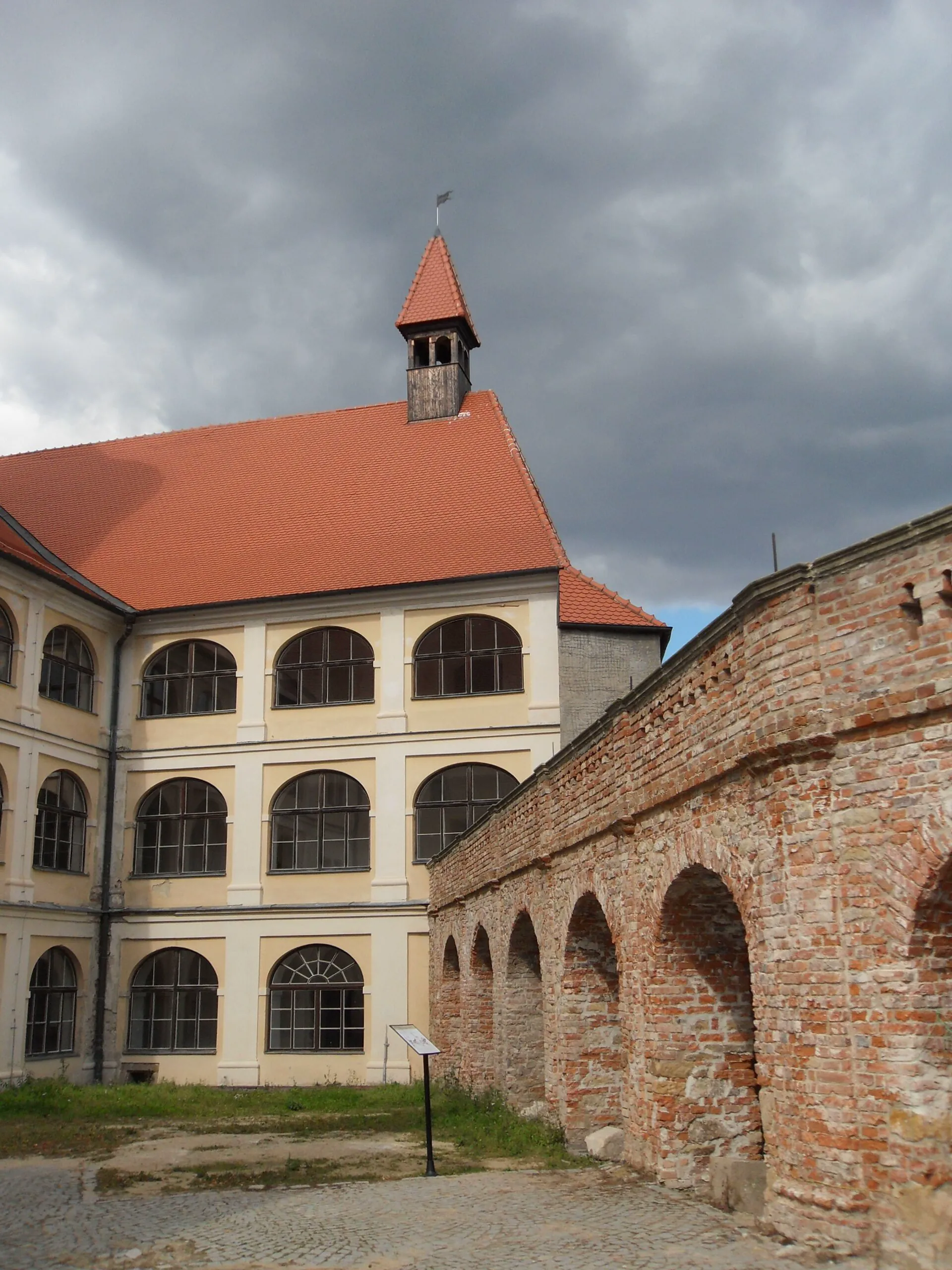 Palác s arkádovým průčelím a cihlová hradba na nádvoří