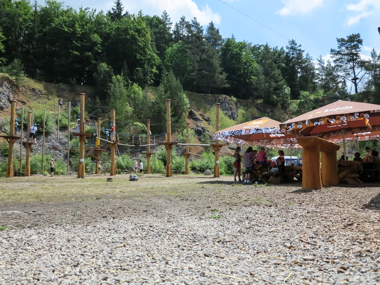 Lanový park s dřevěnými sloupy ve dně bývalého kamenolomu
