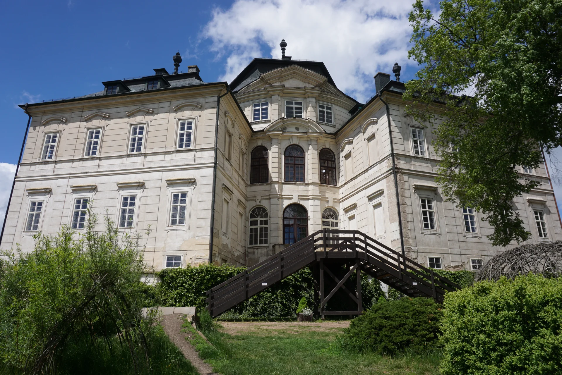 Zadní průčelí zámku Karlova Koruna s dřevěným schodištěm do zahrady