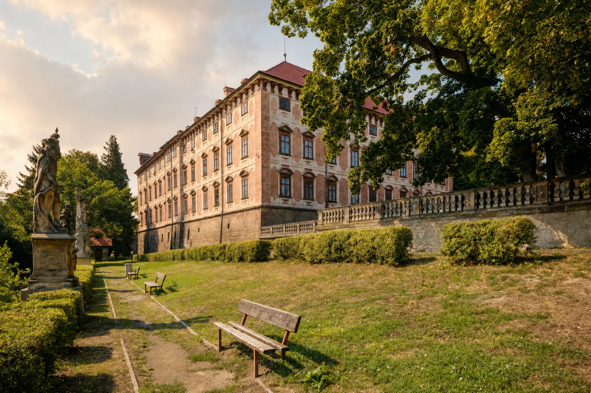 Barokní zámek Libochovice od zámecké zahrady, balustráda se sochou a řada oken průčelí