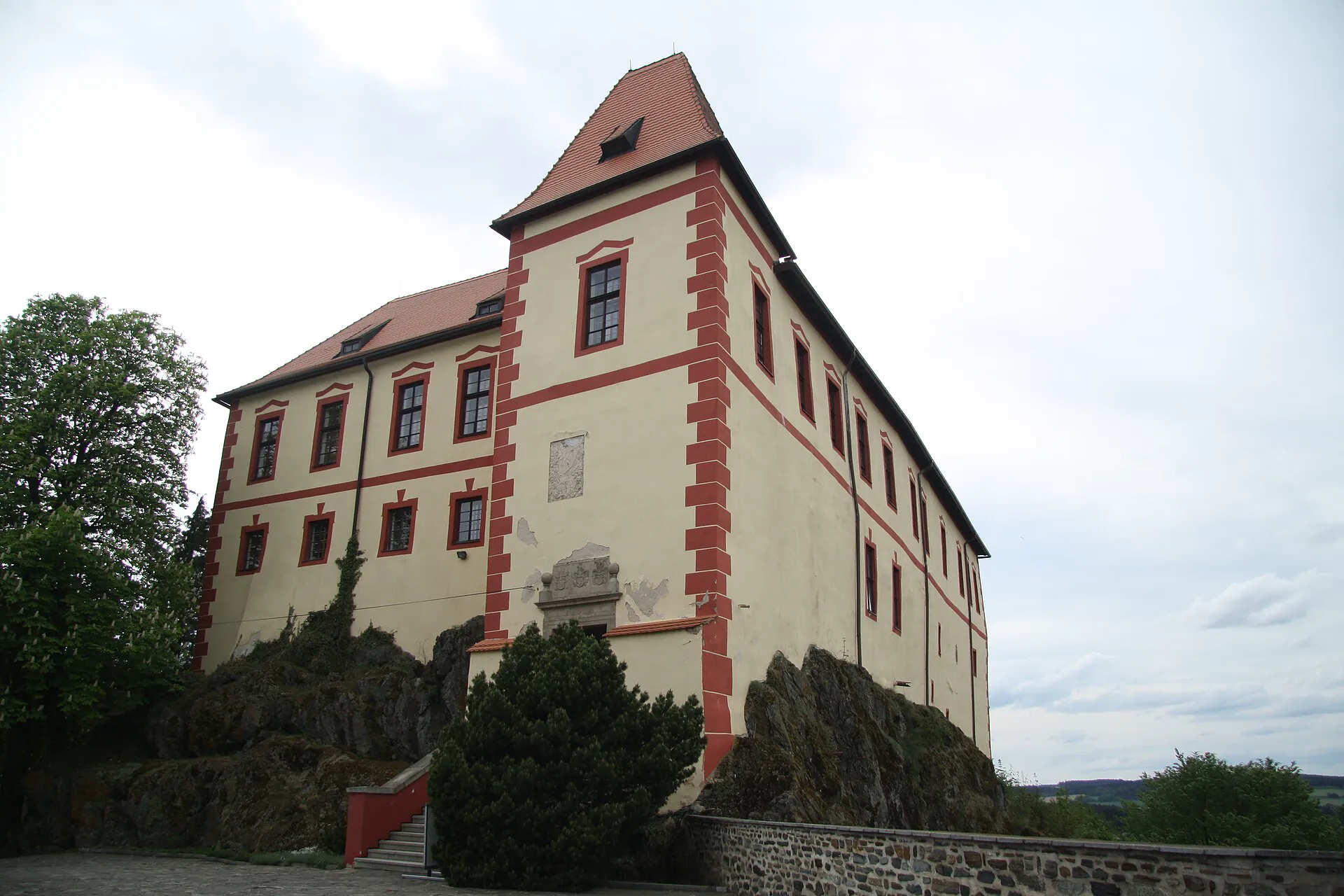 Hrad Kámen s červenobílým průčelím stojící na skalisku