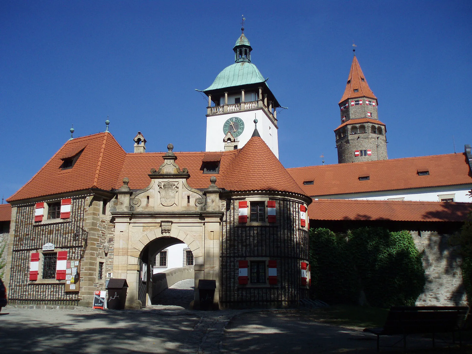 Vstupní brána hradu s věžemi a erby nad průjezdem