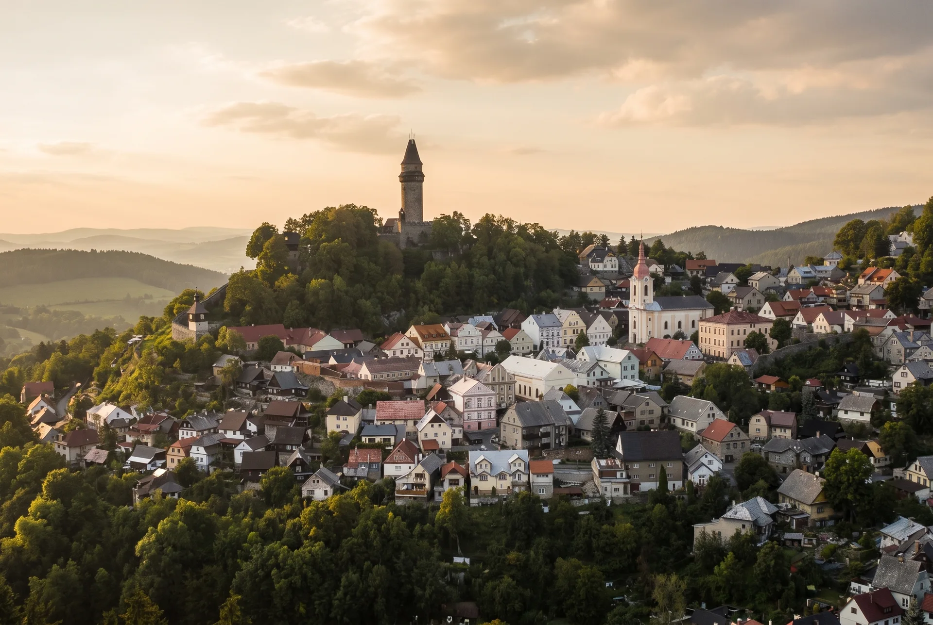 Štramberská Trúba na zalesněném kopci nad městečkem s červenými střechami