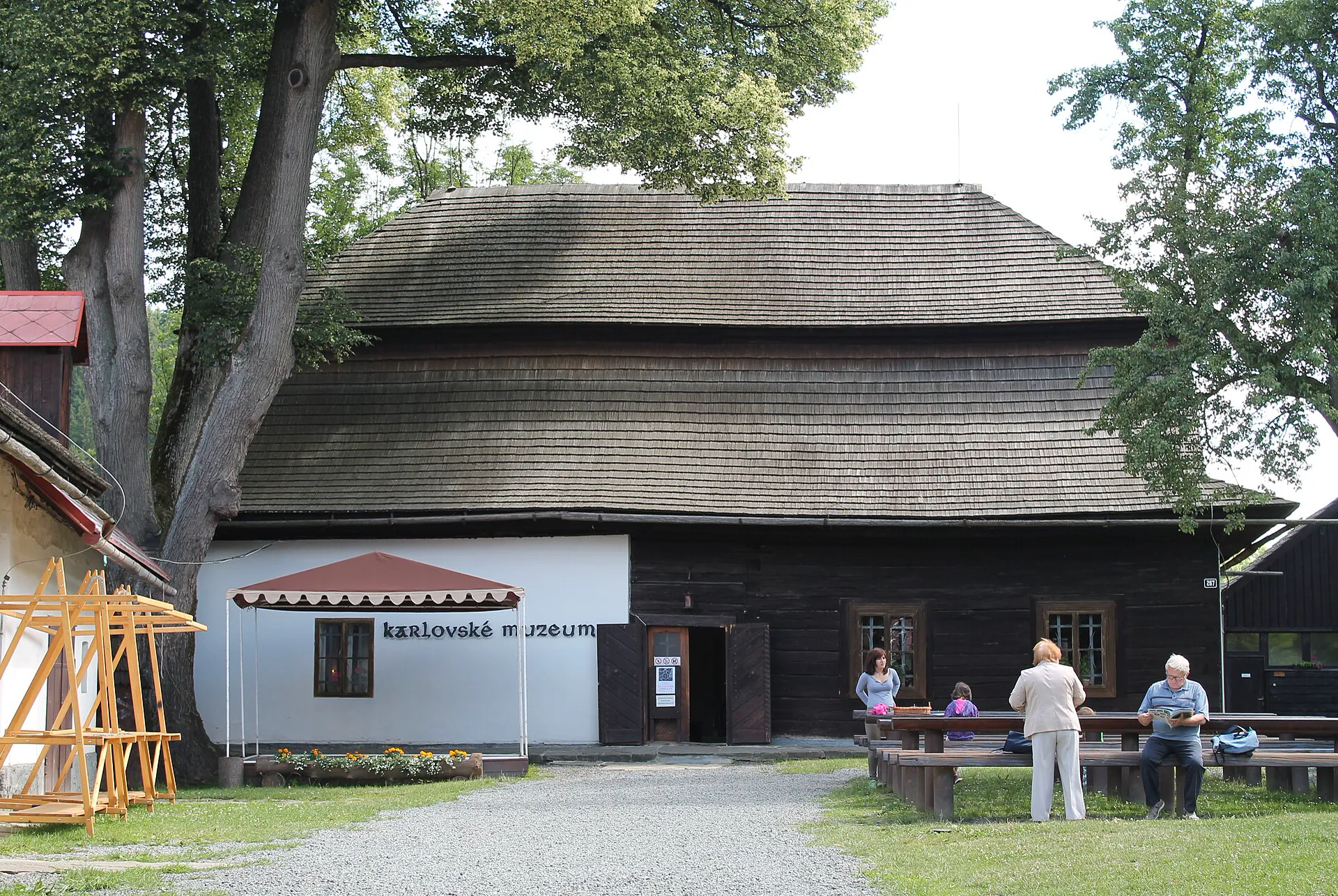 Průčelí muzea s lavičkami a návštěvníky před vstupem