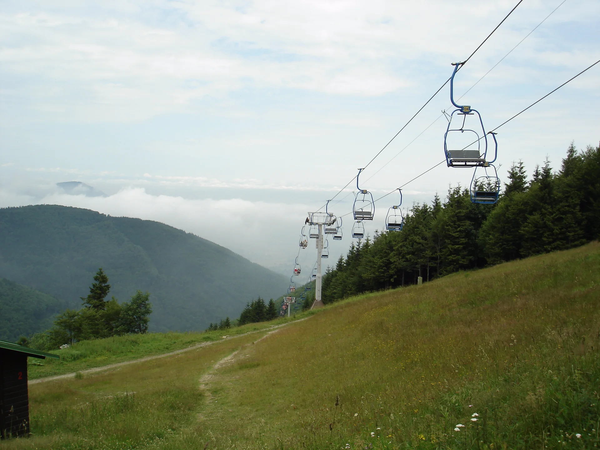 Sedačky lanovky nad loukou na Pustevnách