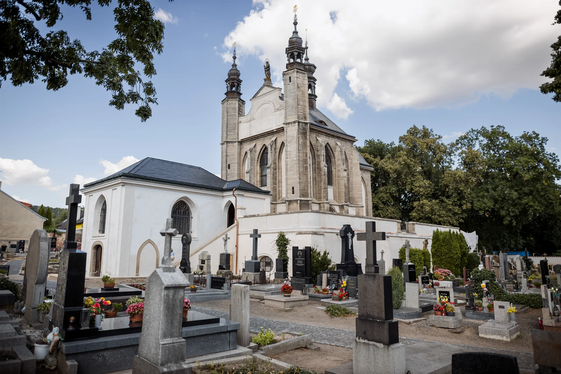 Kostel Všech svatých s kostnicí a dvěma věžemi nad sedleckým hřbitovem