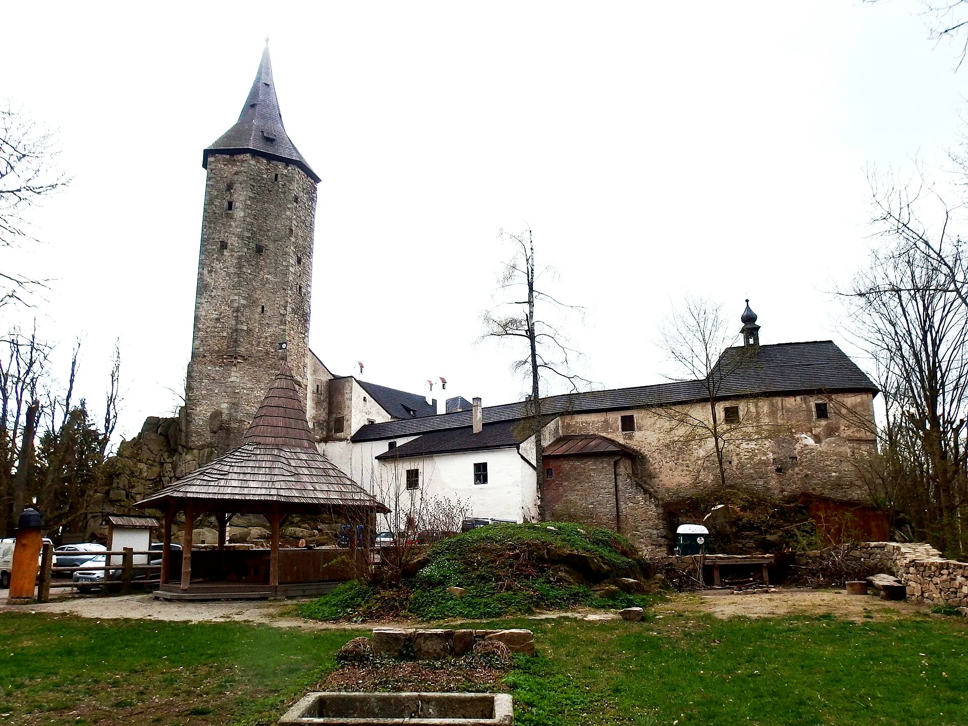 Hrad Roštejn s kamennou věží a šindelovou střechou mezi stromy