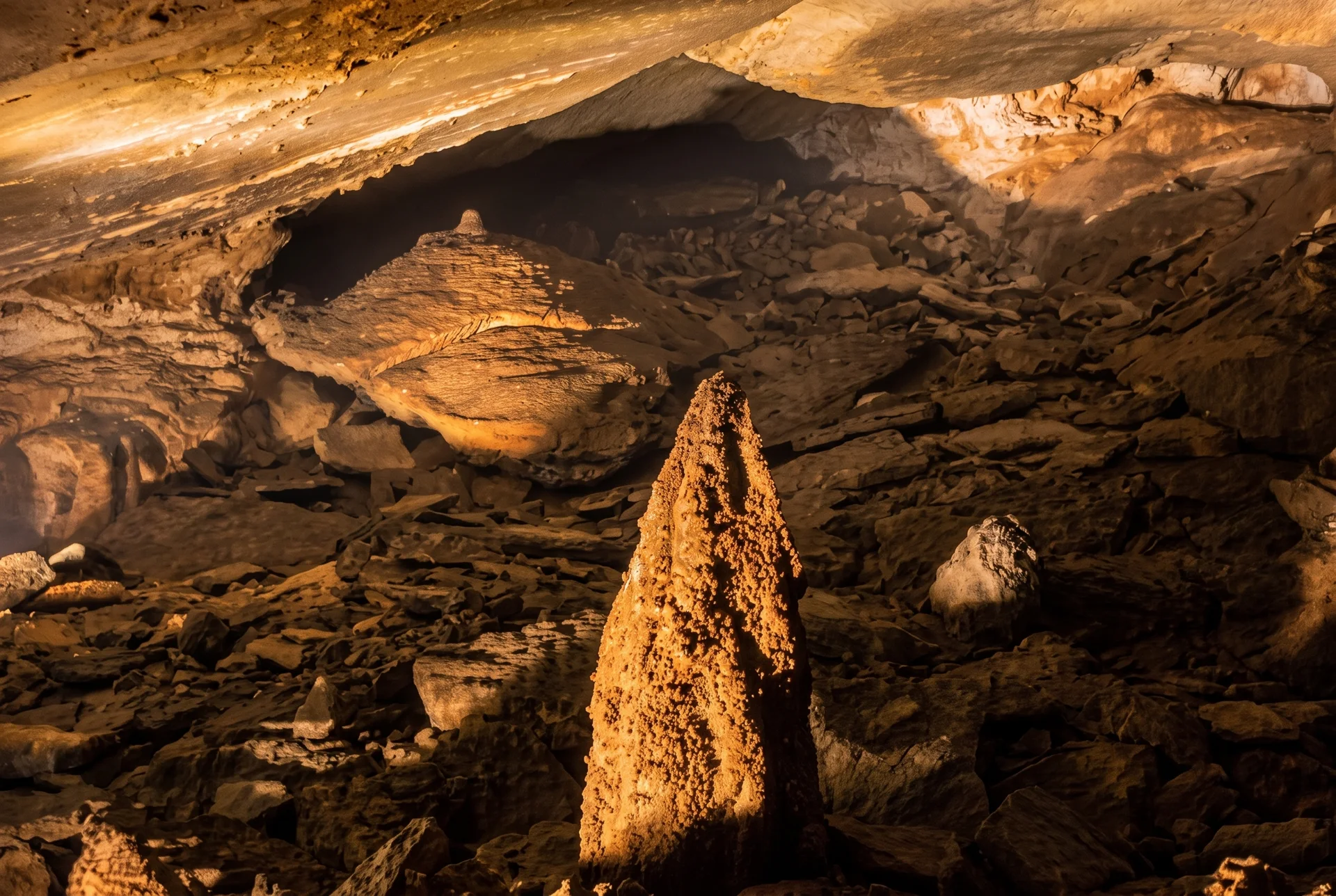 Jeskynní dóm se stalagmitem v rovnoměrném teplém osvětlení