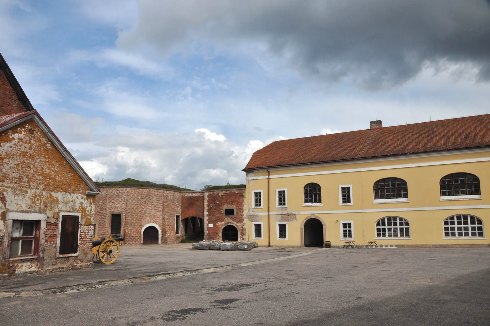 Nádvoří bastionu s cihlovou zdí a žlutou budovou