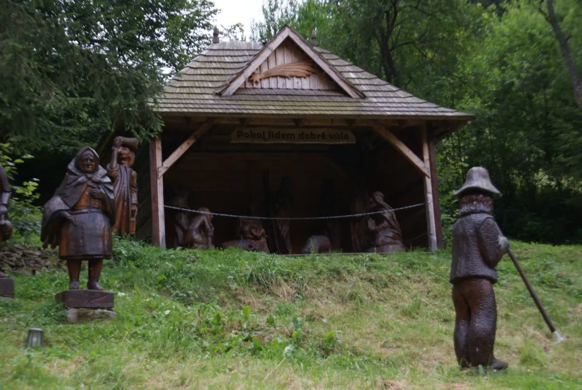Zastřešené dřevěné sousoší s vyřezávanými postavami