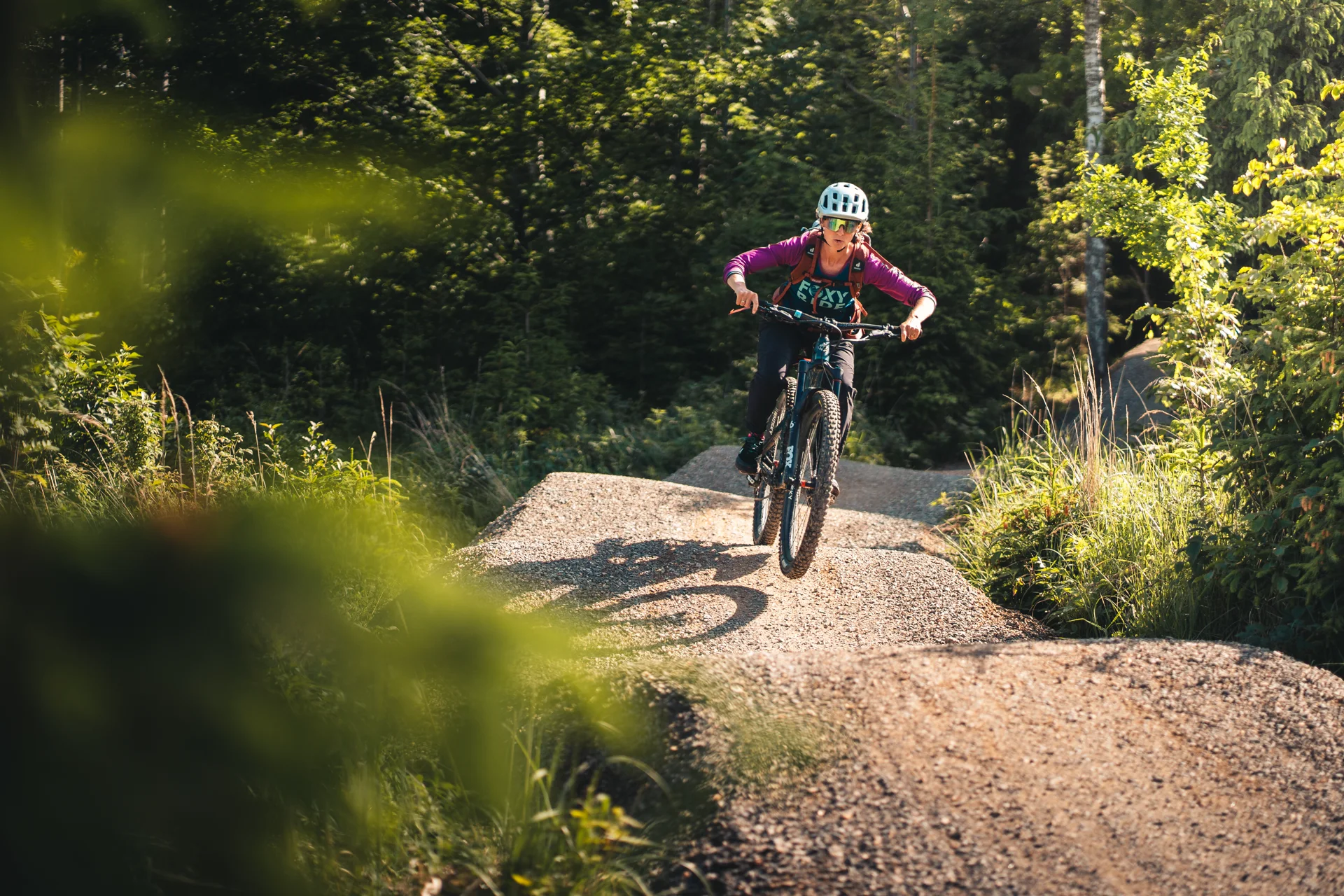 Jezdec na horském kole projíždí klopenou zatáčku singletrailu