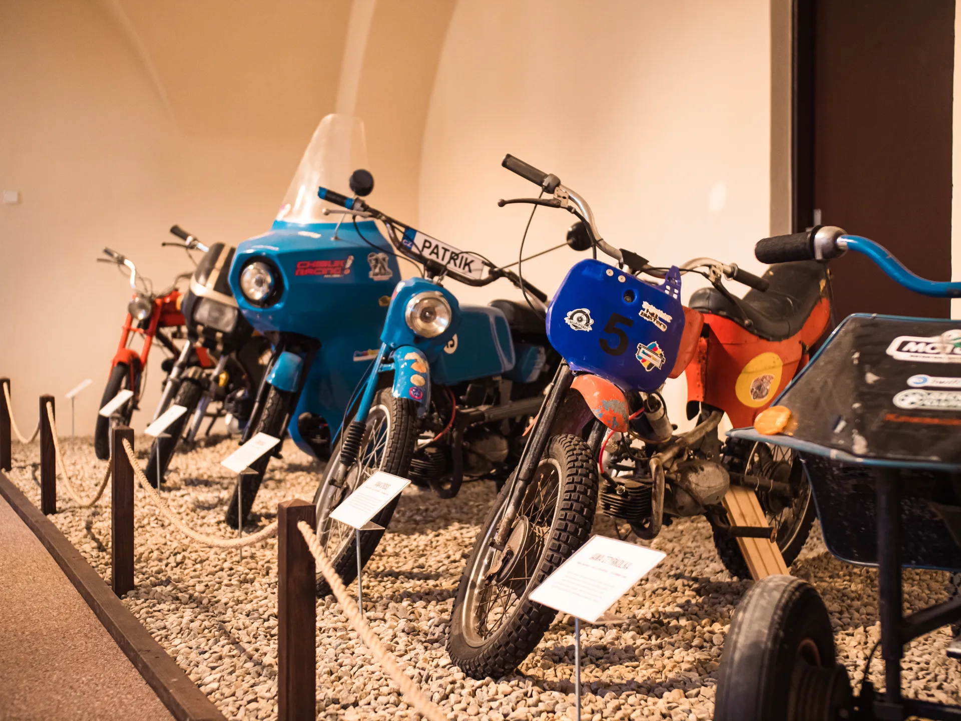 Řada historických motocyklů v expozici starých motorek