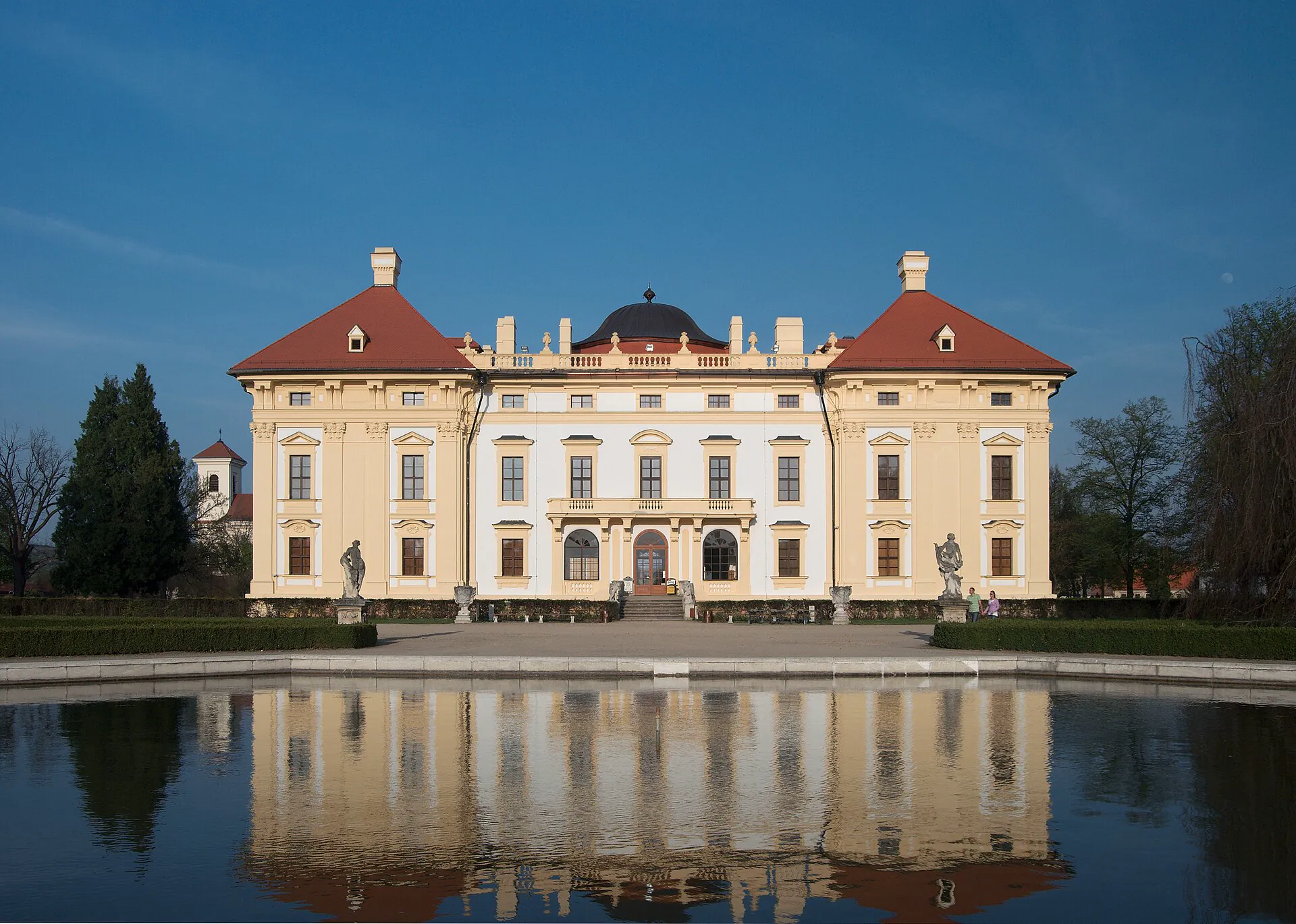 Barokní průčelí zámku zrcadlící se ve vodní ploše