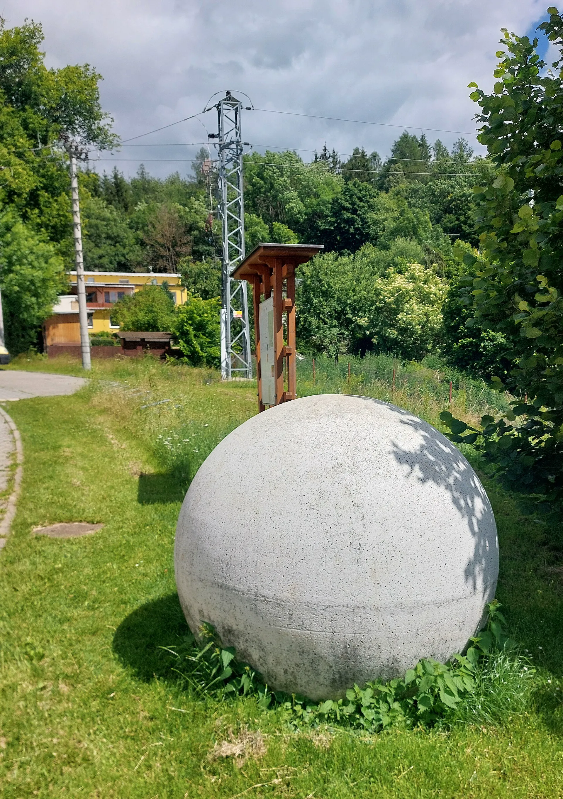 Betonový model planety s informační tabulí na Sluneční stezce v lese u Křtin