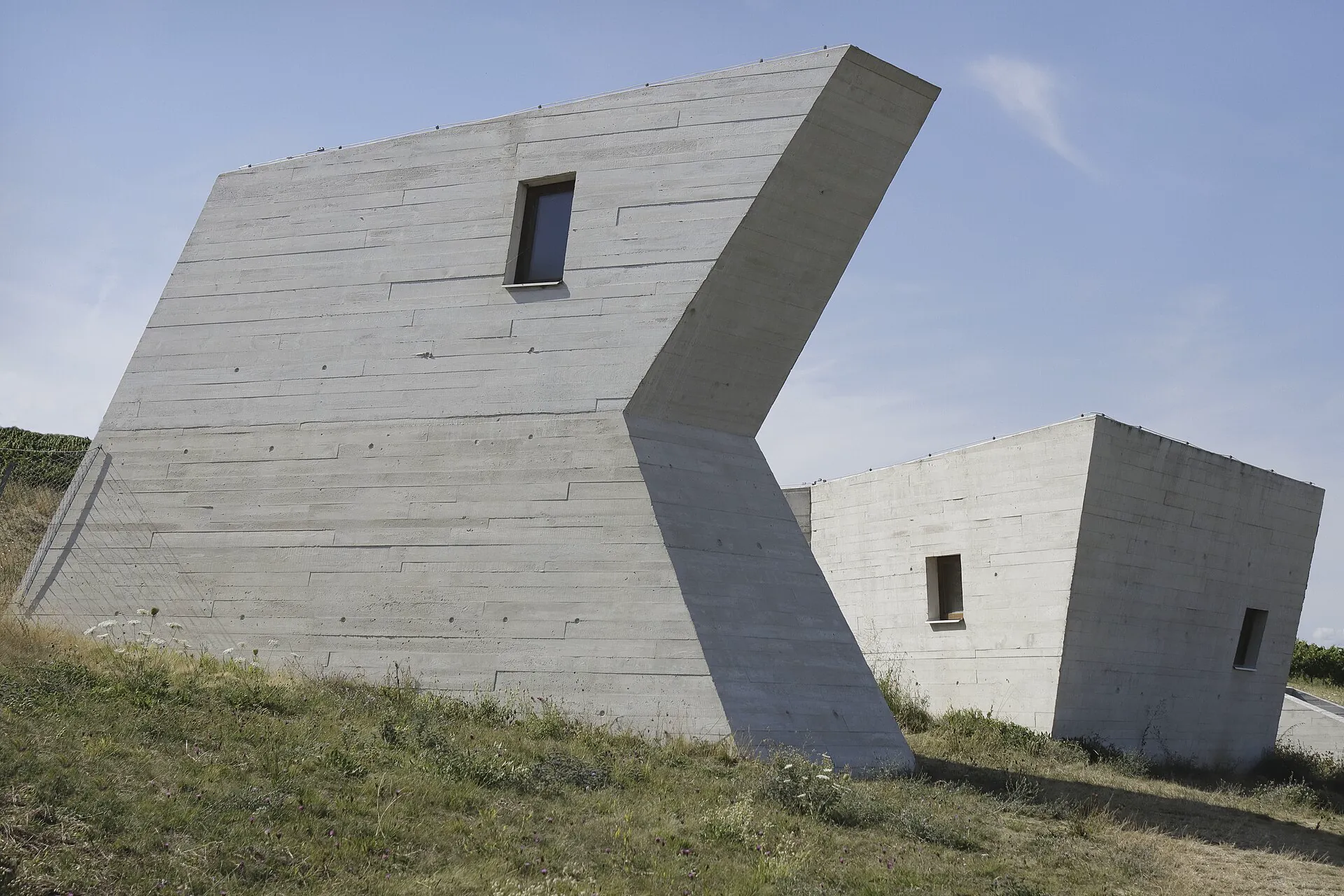 Bílé betonové světlíky archeoparku na letní obloze
