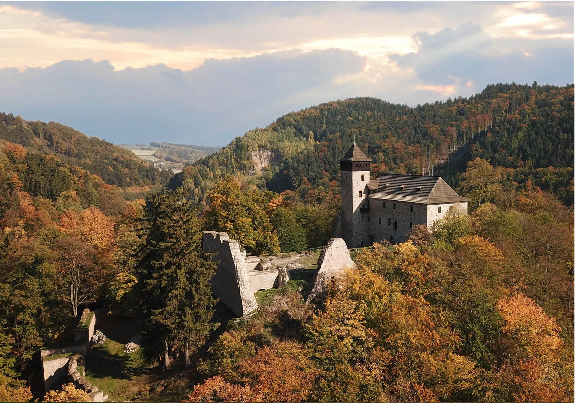 Podzimní letecký pohled na hrad s hranolovou věží a hradbami nad meandrem Divoké Orlice