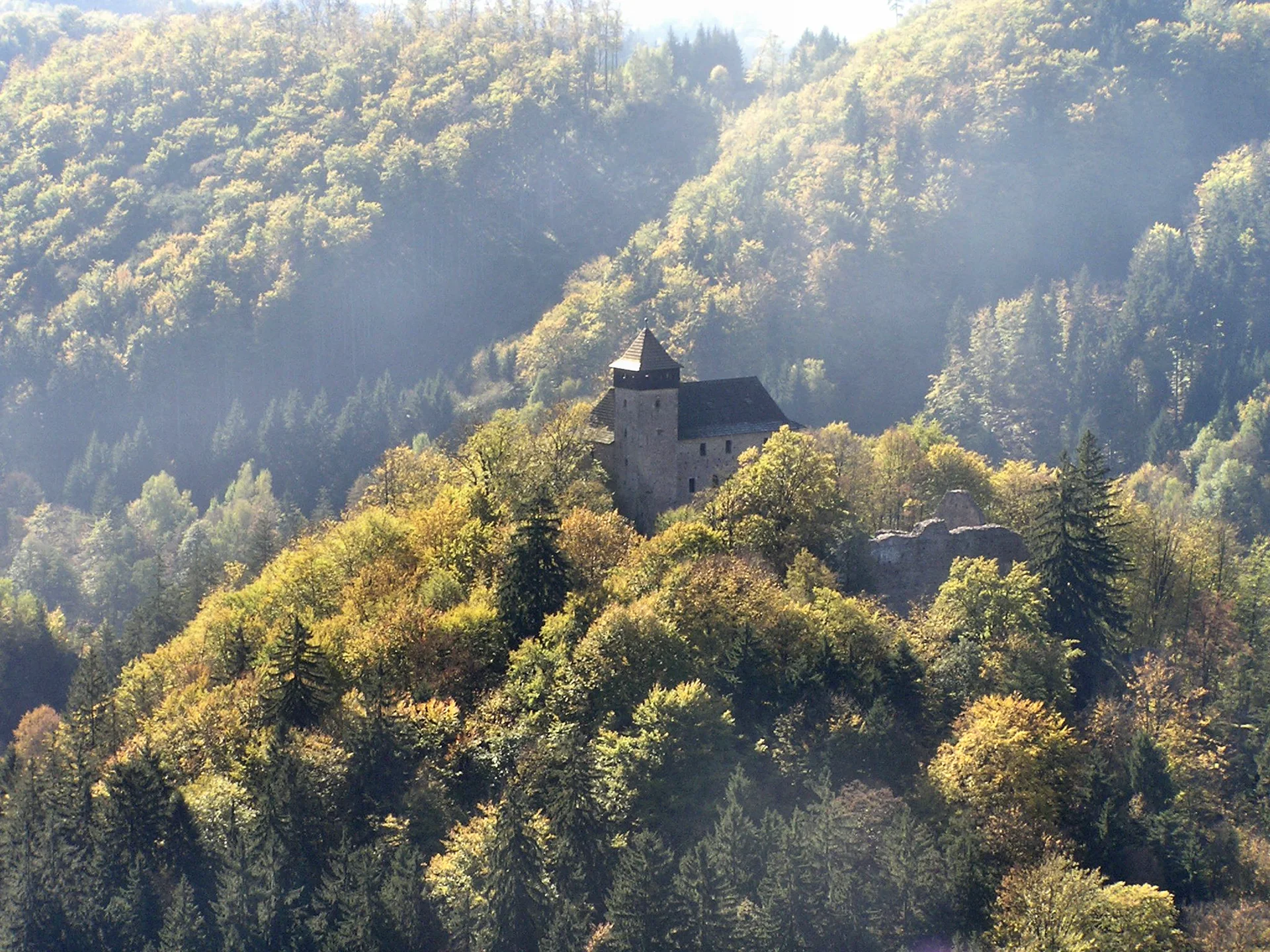 Hrad Litice z ptačí perspektivy, kamenné jádro uprostřed zalesněného ostrohu