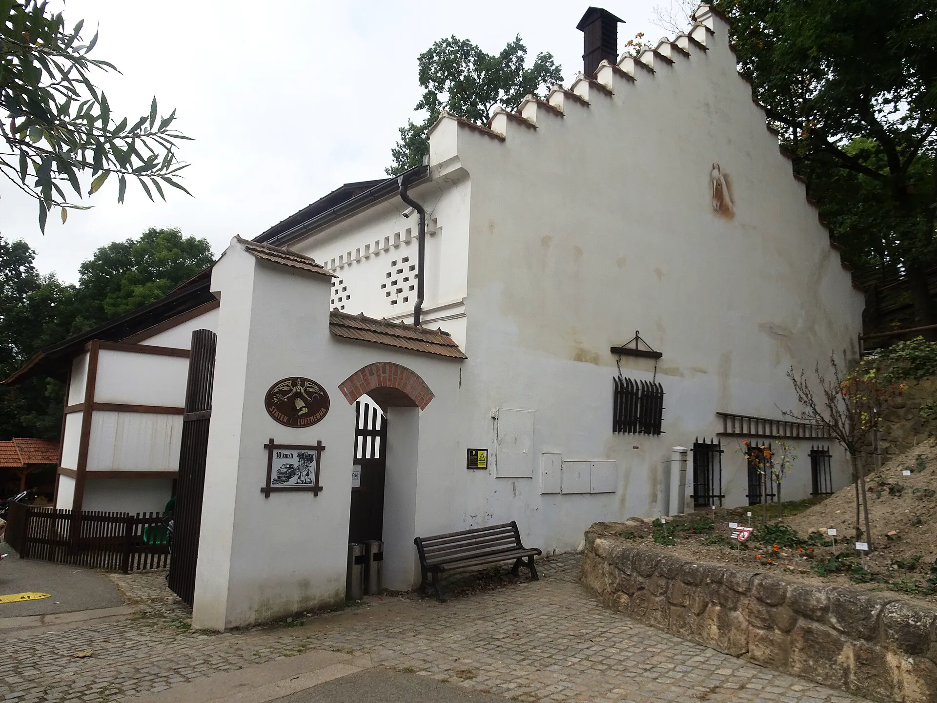 Historický statek Lüftnerka s bílou fasádou a lavičkou u vchodu